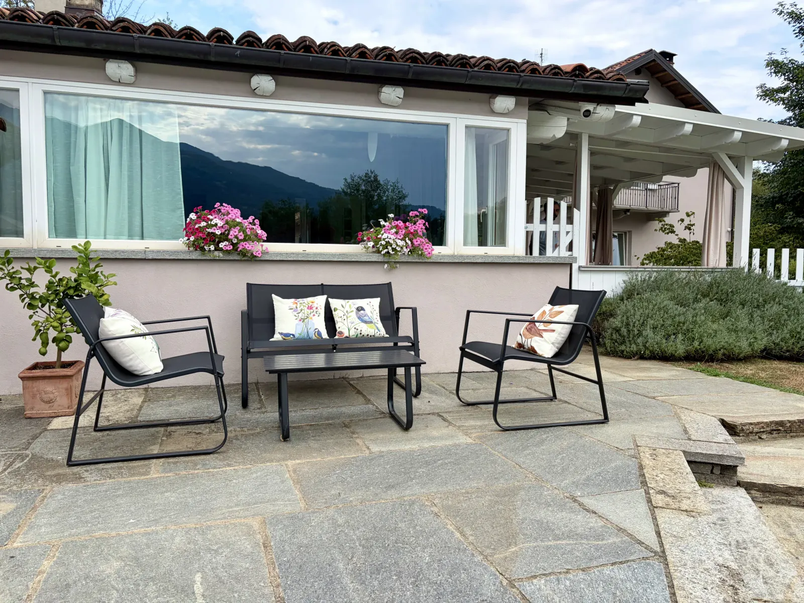 Patio in pietra arredato davanti alla casetta