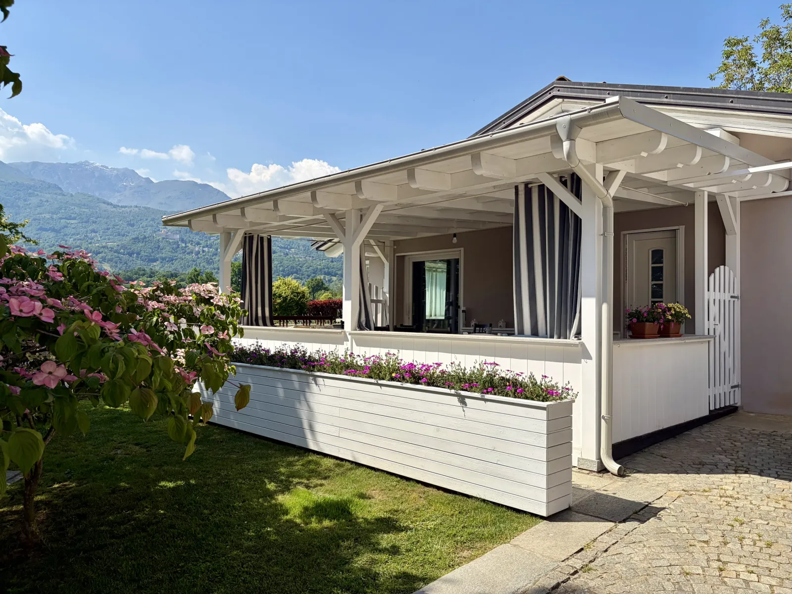Portico in legno bianco decorato con fioriere