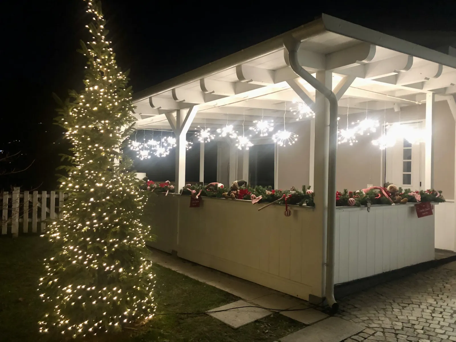Portico addobbato con albero di Natale e luci nella notte