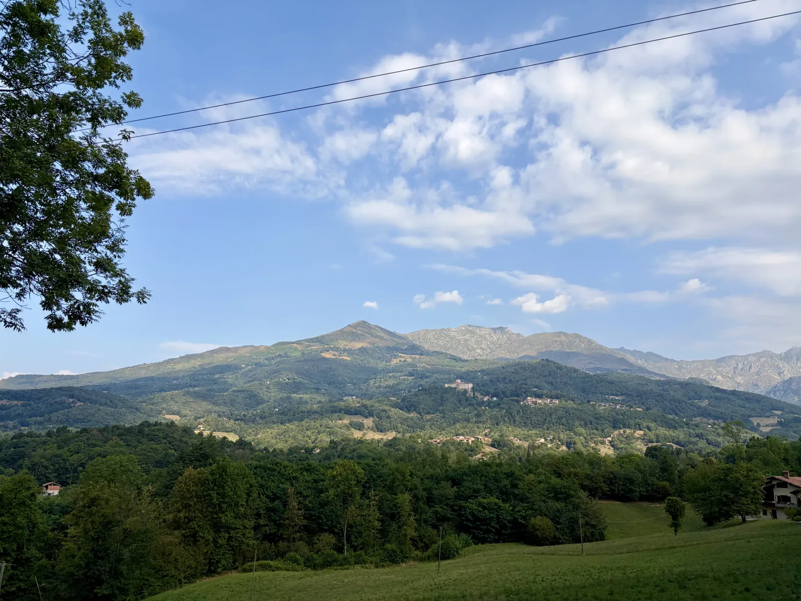 Panorama delle montagne biellesi sotto un cielo azzurro e nuvoloso